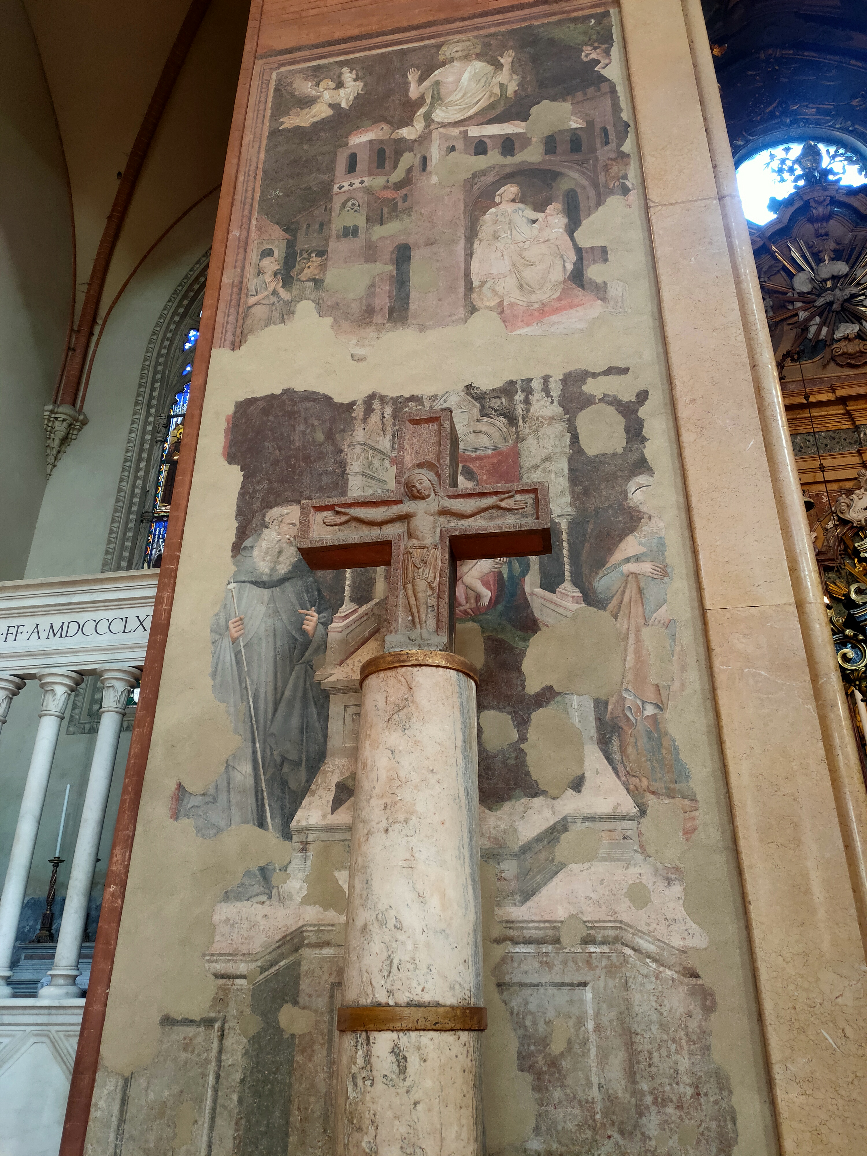 Crocifisso sopra una colonna davanti a un affresco