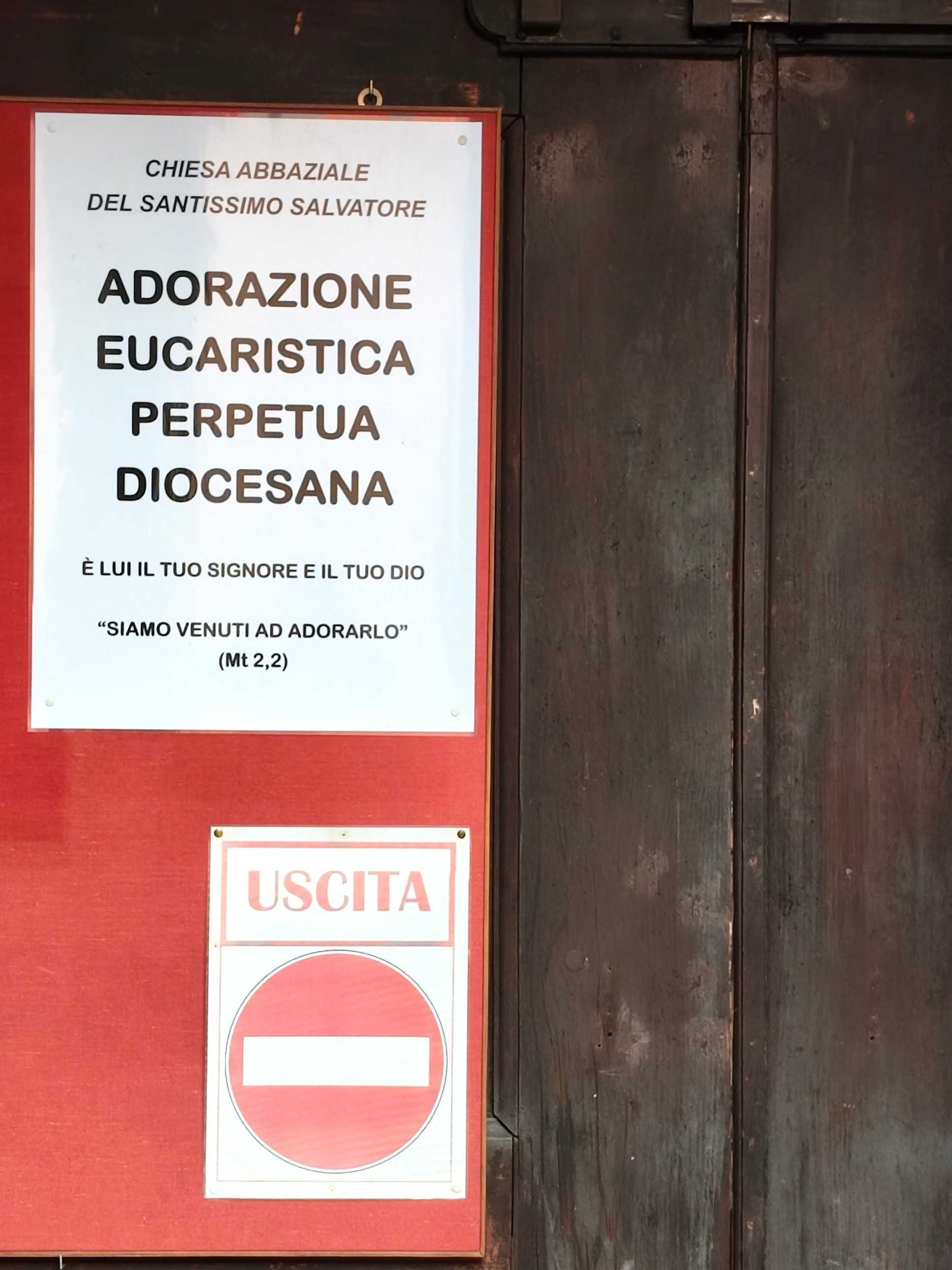 Cartello: Chiesa abbaziale del Santissimo Salvatore, Adorazione eucaristica perpetua diocesana, con il segnale Uscita
